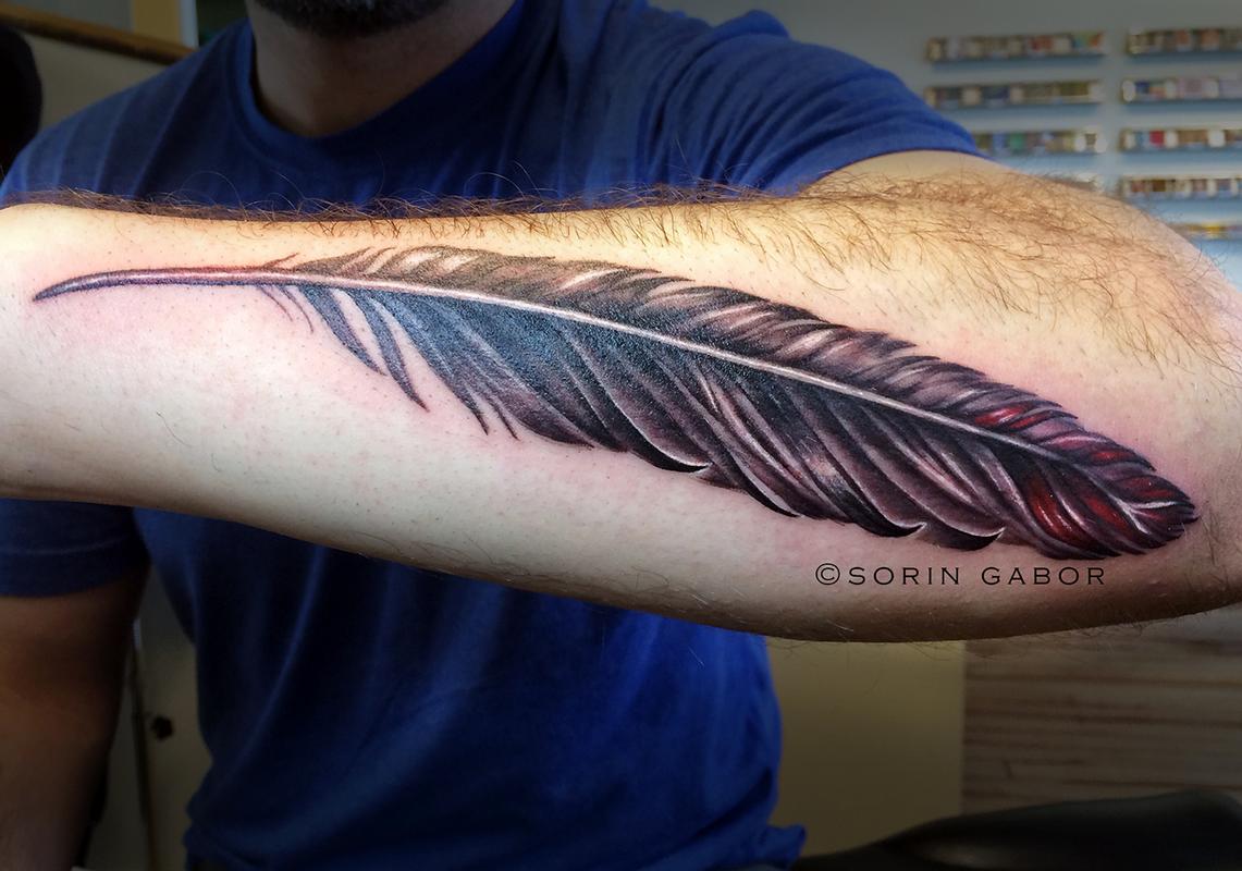 Realistic black and gray with color accent feather on forearm by Sorin